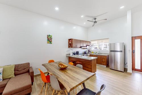 a living room with a wooden table and a kitchen at Casa Eureka in Herradura