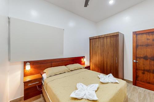 a bedroom with a bed with two white towels on it at Casa Eureka in Herradura
