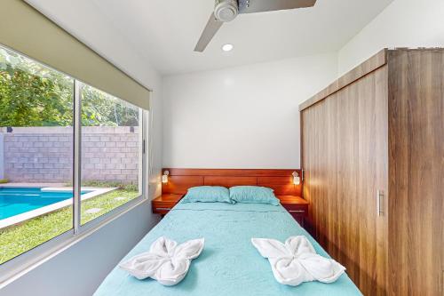 1 dormitorio con cama y piscina en Casa Eureka en Herradura