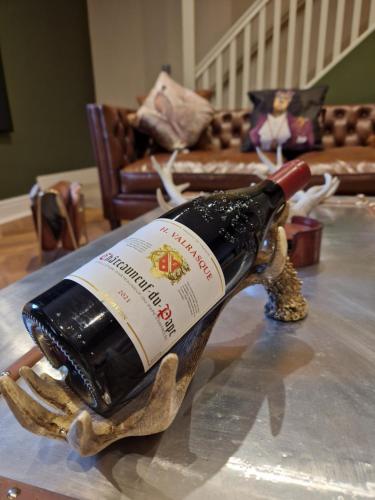 a bottle of wine sitting on top of a table at The Hamilton luxury holiday let's- The Coach House with hot tub in Scorton