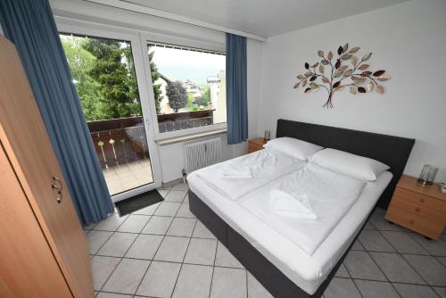 ein Schlafzimmer mit einem Bett und einem großen Fenster in der Unterkunft Areit Living corner top 21 in Zell am See