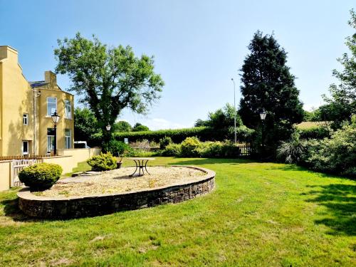 a garden with a bench in front of a house at The Hamilton luxury holiday let's- The Coach House with hot tub in Scorton