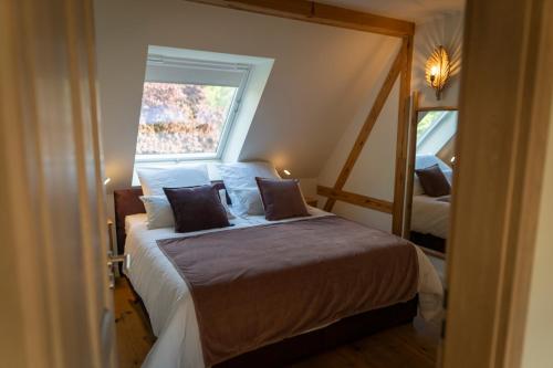 1 dormitorio con 1 cama con ventana y espejo en Spreewald Chalet Wohnung en Kolonie