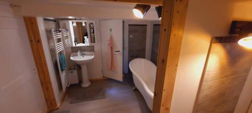 La salle de bains est pourvue d'une baignoire, d'un lavabo et de toilettes. dans l'établissement HEIMELIGE SCHWARZWALD STUBE nahe bei Freiburg, à Todtnau