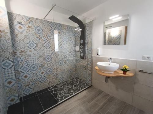 a bathroom with a sink and a shower at Costa di Sopra Affittacamere in Quartu SantʼElena