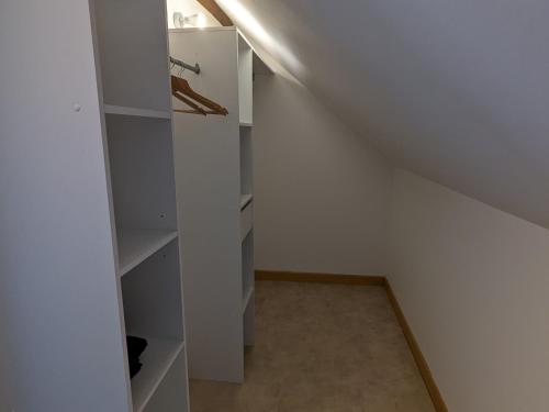 a room with a white closet with a shelf at Gîte lumineux avec jardin paisible entre Montargis et Sully-sur-Loire, idéal familles et pros - FR-1-590-373 in Montereau