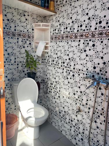 a bathroom with a toilet and a wall with black dots at Moroccan Family House in Agadir