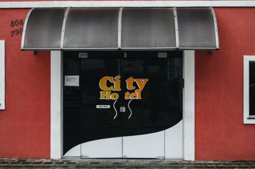 a window of a shop with a sign on it at City Hotel, Curitiba in Curitiba