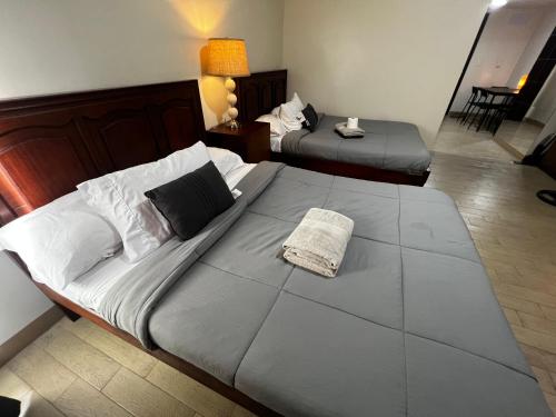 una habitación de hotel con 2 camas y una lámpara en Large studio Cubao with 2 beds en Manila