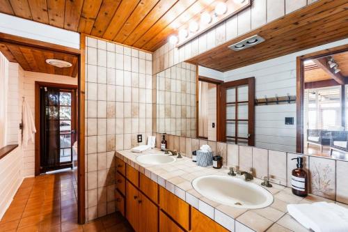 ein Badezimmer mit zwei Waschbecken und einem großen Spiegel in der Unterkunft Neptune Place III - Entire Home Beachfront Retreat in San Diego
