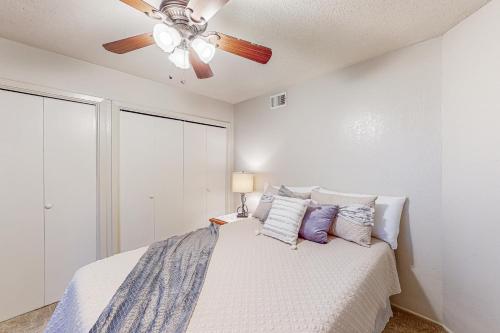 a bedroom with a ceiling fan and a bed with pillows at Traditions in College Station