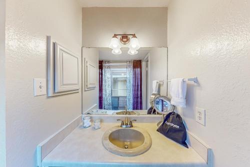La salle de bains est pourvue d'un lavabo et d'un miroir. dans l'établissement Traditions, à College Station
