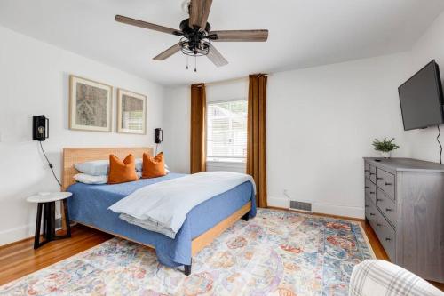 a bedroom with a blue bed and a ceiling fan at Deacon Stays: The Polo - Walk to WFU in Winston-Salem