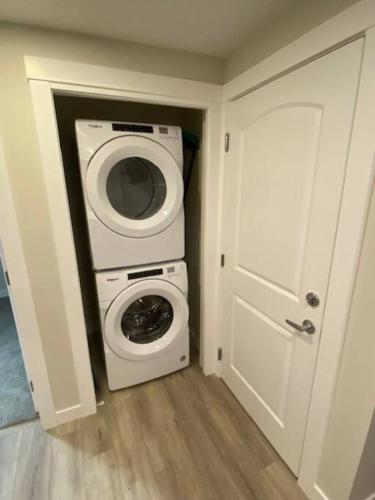 a laundry room with a washing machine and a washer at Cozy brand new 2 bedroom suite in Calgary in Calgary