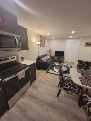 a kitchen and living room with a table and a couch at Cozy brand new 2 bedroom suite in Calgary in Calgary