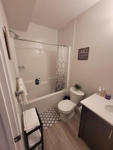 a bathroom with a toilet and a shower and a sink at Cozy brand new 2 bedroom suite in Calgary in Calgary