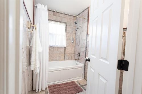 a white bathroom with a tub and a shower at The Chattanooga Chill-Out in Ooltewah