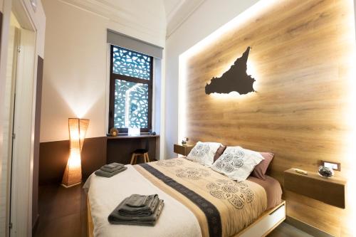 a bedroom with a bed with a wooden headboard at Etna Hills in Catania