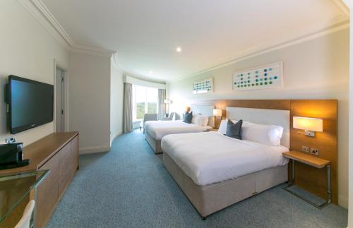 a hotel room with two beds and a flat screen tv at Portmarnock Resort & Jameson Golf Links in Portmarnock