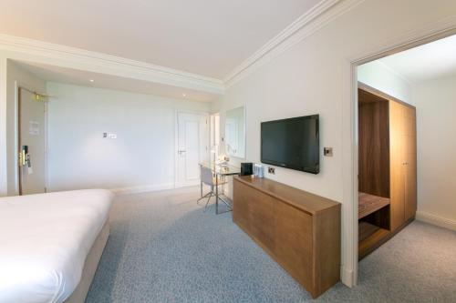a hotel room with a bed and a flat screen tv at Portmarnock Resort & Jameson Golf Links in Portmarnock