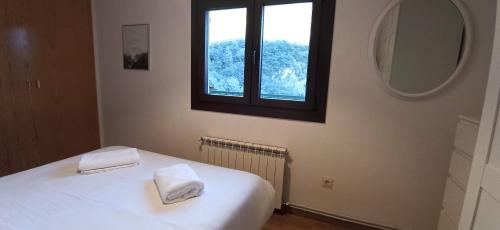 ein Schlafzimmer mit einem weißen Bett mit zwei Handtüchern darauf in der Unterkunft Mirador de Sanvi in Escarrilla