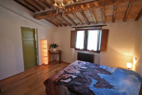a bedroom with a bed and a window at Casetta del Pozzo in Seggiano