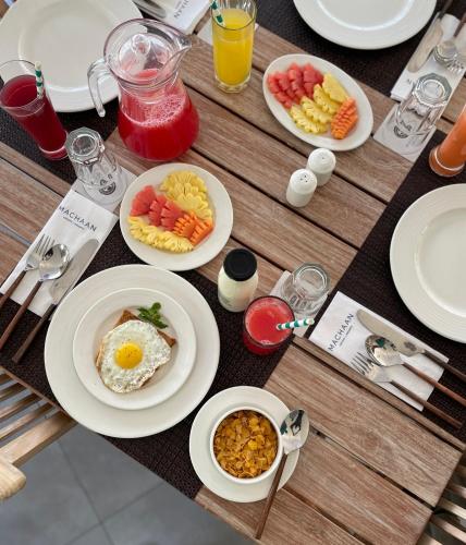 a wooden table with plates of breakfast food on it at Machaan Wilderness Lodge Nagarahole in Srimangala