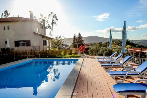 ein Pool mit Liegestühlen neben einem Haus in der Unterkunft Martins House Quartos in Arouca