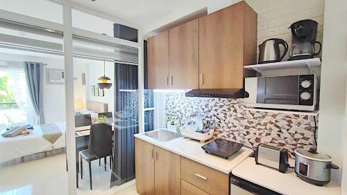 a kitchen with a sink and a microwave at CityCondo, 2nd Fl, 30 sqm, near CPU, balcony and parkview, Netflix, free parking in Iloilo City