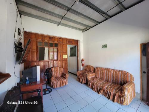 a living room with two couches and a tv at Hostel Rossy in San Juan del Sur