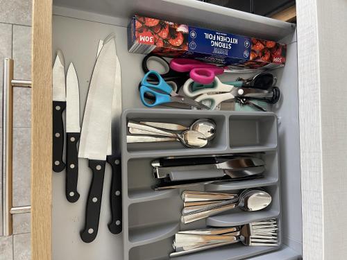 a drawer full of kitchen utensils in a cabinet at Charlesworth House in Crewe