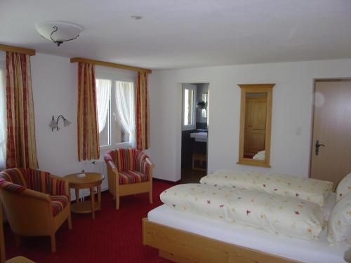 a bedroom with a bed and a table and chairs at Hotel Blumental in Mürren
