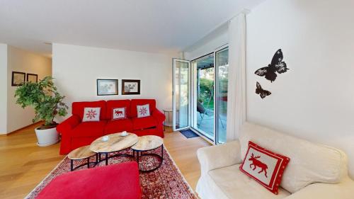 a living room with a red couch and a table at Ferienwohnung für 5 Personen Piz Linard Lantsch-Lenzerheide in Lenz