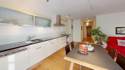 a kitchen and living room with a table with a cake on it at Ferienwohnung für 5 Personen Piz Linard Lantsch-Lenzerheide in Lenz