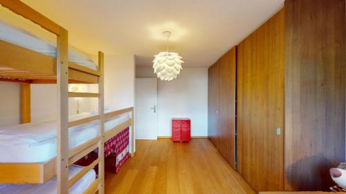 a bedroom with two bunk beds and a chandelier at Ferienwohnung für 5 Personen Piz Linard Lantsch-Lenzerheide in Lenz