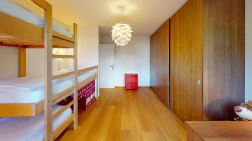 a bedroom with two bunk beds and a chandelier at Ferienwohnung für 5 Personen Piz Linard Lantsch-Lenzerheide in Lenz