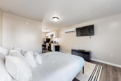 Schlafzimmer mit einem weißen Bett und einem Flachbild-TV in der Unterkunft Royal Blue Villa 2 in La Follette
