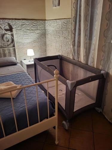 Schlafzimmer mit einem Bett mit blauer Tagesdecke in der Unterkunft Il Gelsomineto dell'Etna in Nicolosi