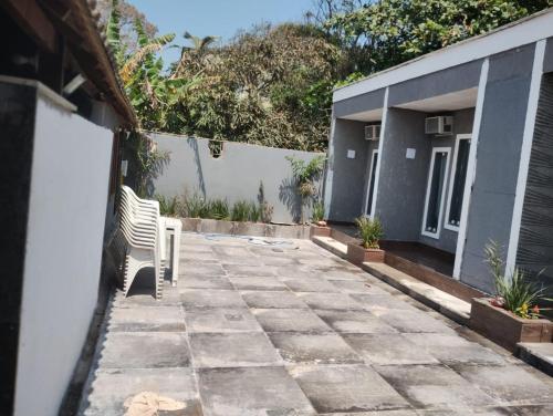 a patio with a chair in front of a house at Pousada Recanto Beach House - Cabo Frio - RJ- Unamar- Cond Florestinha - 1 min a pé da praia in Tamoios