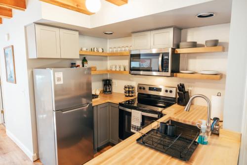 a kitchen with a stainless steel refrigerator and cabinets at Newly Renovated, Spacious Condo, 3 min to the ski lifts! in Bethel