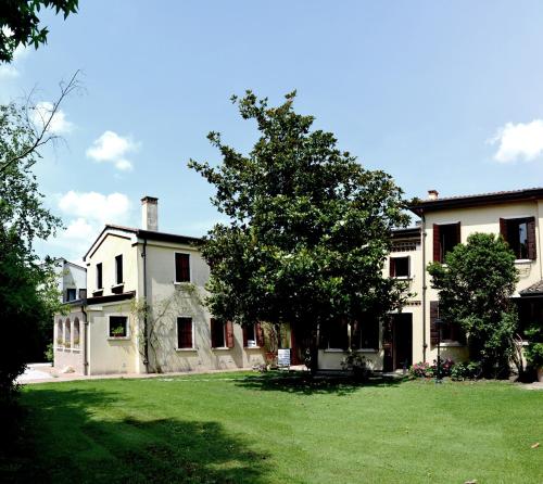 a large white house with a tree in the yard at B&B Casa Camilla in Padova