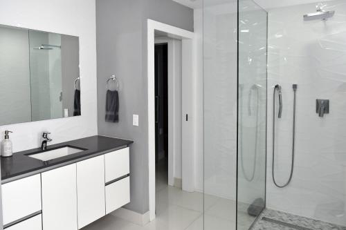マイアミにあるLuxurious Home with BBQ, Hot Tub, Heated Pool & Wifi - L36の洗面台とガラスのシャワーを備えたバスルーム