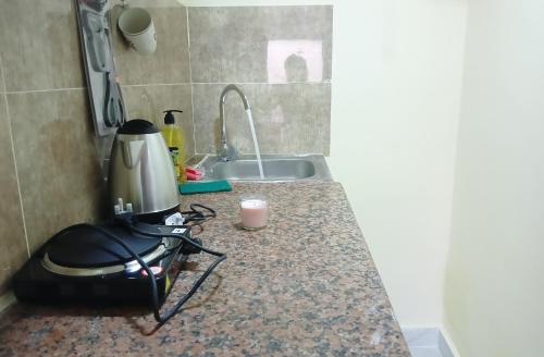 a kitchen counter with a blender and a sink at King bed-Studio Room Near "al bateen" Abudhabi in Abu Dhabi