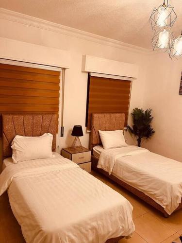una camera con due letti e un lampadario a braccio di Lovely 3 bedrooms rental unit ad Aqaba