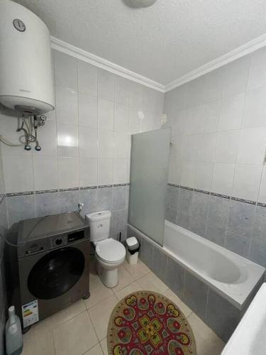 a bathroom with a toilet and a tub and a sink at Lovely 3 bedrooms rental unit in Aqaba