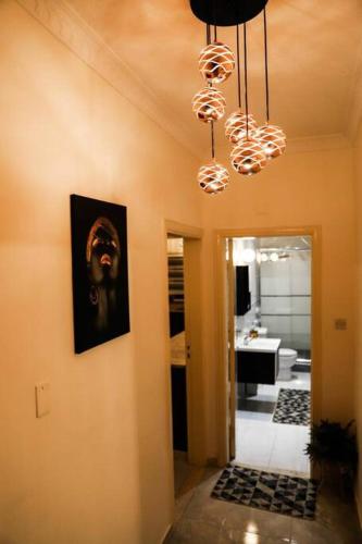 un corridoio con un dipinto sul muro e un lampadario a braccio di Lovely 3 bedrooms rental unit ad Aqaba