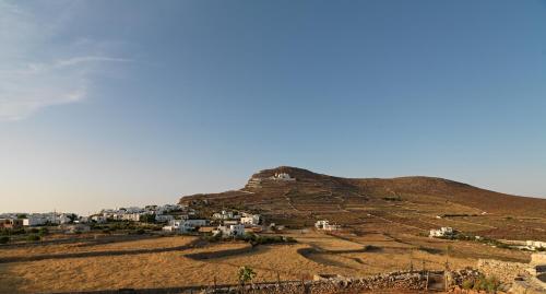 a hill with a village on top of it at Themonies Luxury Suites in Chora Folegandros