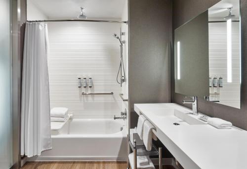 y baño con bañera, lavamanos y ducha. en AC Hotel by Marriott Miami Aventura en Aventura