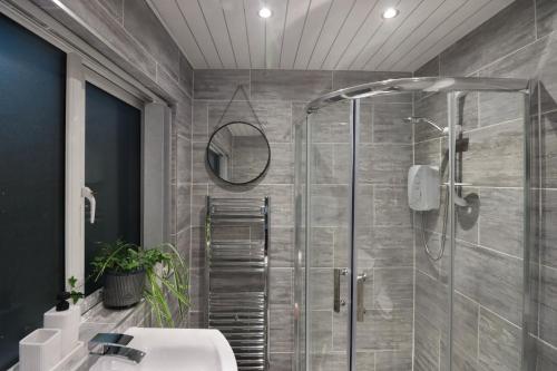 een badkamer met een douche en een wastafel bij A Lil cosy Belfast home in Belfast