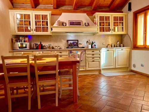 a kitchen with white cabinets and a wooden table at Appartamento Corte Antica in Bellagio